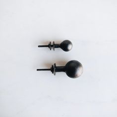 two black door knobs on a white surface