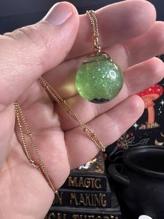 Step into a world of magic and whimsy with my unique liquid fidget jewelry! The light green shimmer, larger sparkles, and 5 tiny black pearls reminiscent of frog eggs will mesmerize your family and friends alike with the captivating swirls that come to life with your natural body movements!  The shiny "fairy dust" give these globes a magical allure. As it sits, the sparkles settle to the bottom to coat the tiny pearls at the bottom of the globe. When you give it a gentle shake, watch in awe as it comes alive with mesmerizing swirls of color. Truly captivating in direct sunshine, the camera just can't capture how mesmerizing the swirls are!  These are lovingly made by hand to order; slight variations in color, density, and the UV resin seal shape are expected! My processing times can also b Magical Gold Jewelry For Party, Green Luminous Round Jewelry, Whimsical Adjustable Iridescent Jewelry, Magical Gold Nickel-free Jewelry, Whimsical Green Dangle Jewelry, Green Hypoallergenic Jewelry Gift, Whimsical Green Nickel-free Jewelry, Hypoallergenic Green Jewelry Gift, Whimsical Resin Jewelry For Party