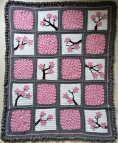 a crocheted blanket with pink flowers on it and the words how to make a cherry blossom crochet blanket looks lovely and the colours are so happy