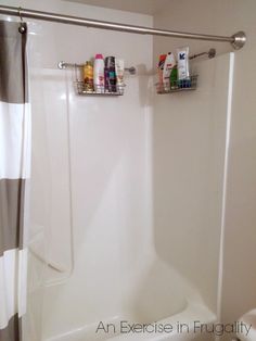 a bathroom with a shower curtain, toilet paper holder and bathtub caddy on the wall