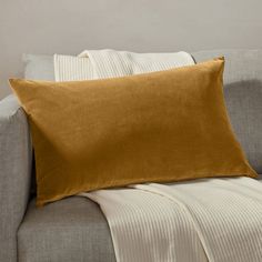 a brown pillow sitting on top of a gray couch