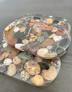 two clear trays filled with rocks on top of a wooden table