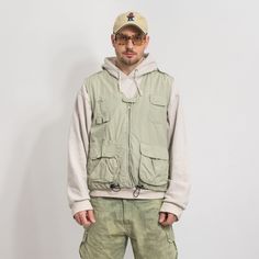 "Vintage utility cargo vest - with a front zip - lined - materials: 36% nylon, 64% cotton SIZE: L MEASUREMENTS chest: 48 inches (122 cm) length: 26 inches (66 cm) The model is 6'1\" (186 cm), measures 41-35-39 (104-88-100 cm) and typically wears clothing in size L CONDITION - 8/10 - The vest in great vintage condition. Washed, ready to wear." Spring Outdoor Vest With Side Pockets, Casual Nylon Vest With Multiple Pockets, Outdoor Spring Vest With Side Pockets, Urban Style Outdoor Vest With Pockets, Sleeveless Cargo Pocket Outerwear For Spring, Functional Spring Vest With Pockets, Spring Functional Vest With Pockets, Spring Nylon Vest With Pockets, Urban Style Vest With Pockets For Outdoor