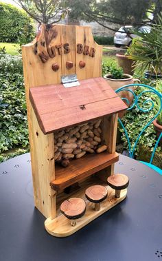 a wooden kiosk sitting on top of a table next to some wood slices