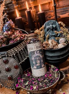 a bottle of wine sitting on top of a wooden table next to candles and other items