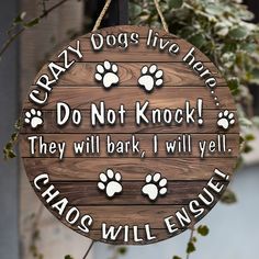 a wooden sign that says crazy dogs live here do not knock they will bark i will yell