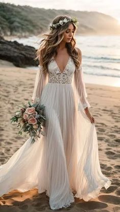 a woman standing on top of a beach wearing a white dress and holding a bouquet