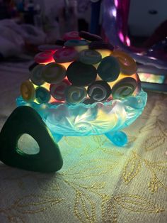 a glass bowl filled with buttons sitting on top of a table