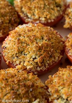 several stuffed tomatoes with cheese and seasoning sprinkled on top, ready to be eaten