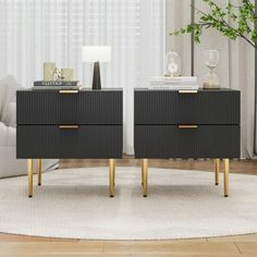 two black nightstands with gold legs in front of a white couch and table next to each other