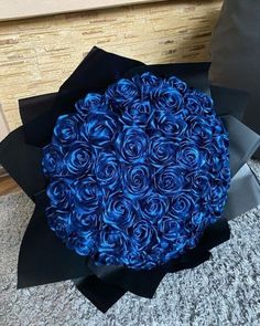 a bouquet of blue roses sitting on top of a black box