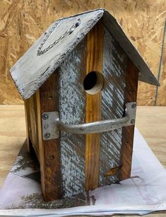 a wooden birdhouse sitting on top of a piece of paper