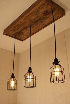 three light fixtures hanging from a wooden beam