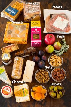 an assortment of food that includes cheese, nuts, crackers, apples and other items