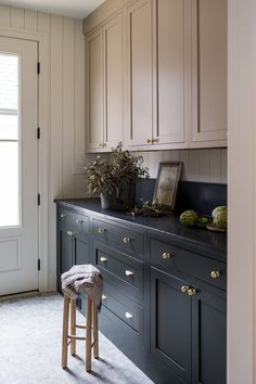 a kitchen with wooden cabinets and stools in front of the counter top, next to a window