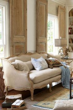 a living room filled with furniture and lots of windows