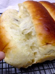 a person is holding a piece of bread on a cooling rack with it's crust