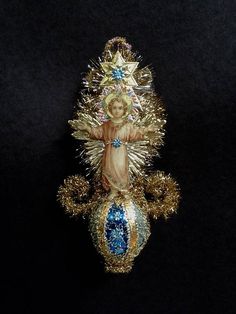 a gold and blue christmas ornament with an image of the virgin mary on it