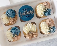 six decorated cupcakes in a white box with blue frosting and the words happy father's day written on them