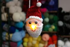 a light up santa claus ornament hanging from a string