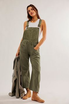 Our top-rated Good Luck Barrel Jeans — now in a timeless overall silhouette! Featuring the signature barrel-leg fit, you’ll be reaching for this pair all season long. **Fit:** Bib-and-brace design with wide barrel-leg **Features:** Front bib pocket, tapered knee design, adjustable brace straps, side button detailing **Why We ❤ It:** Toughened-up with moto boots or laid-back with sporty sneakers, this pair has endless ways to wear. | We The Free Good Luck Barrel Overalls at Free People in Green, Green Overalls, Town Outfits, Weeping Willow, Sporty Sneakers, Lucky You, Jumpsuit Fashion, Denim Overalls, Look At You, Moto Boots