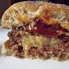 a close up of a sandwich on a plate with ketchup and meat in the middle