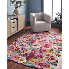 a living room area with a chair, rug and flowered rug on the floor