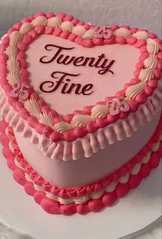 a heart shaped cake with the words twenty fine on it's frosting and pink icing