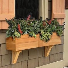 a wooden window box with plants in it