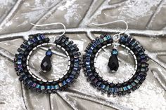 Handmade black boho statement earrings in the most gorgeous mix of iridescent and black beads. These artisan beaded hoop earrings were made with several sizes and shapes of seed beads. Each tiny bead is selected and hand sewn into place, one at a time with a needle and thread. No plastics, no glue, no looms - completely hand stitched with strong nylon thread.✔️Ear wires are sterling silver.✔️handmade in the USA✔️ships boxed and ready to gift in 3-5 business days with care instructions✔️lightweig Black Boho, Beaded Hoop Earrings, Beaded Hoops, Needle And Thread, Black Beads, Hand Stitched, Ear Wires, Hand Sewn, Handmade Silver