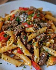 a white plate topped with pasta and meat