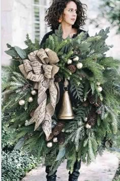 a woman holding a christmas wreath with bells