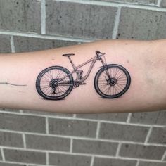 a tattoo on the arm of a man with a bicycle in it's center