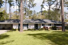 a white house surrounded by trees and grass