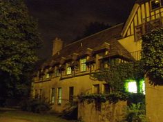 an old building with ivy growing on it's sides and windows at night time