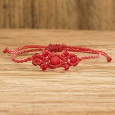 two red bracelets sitting on top of a wooden table