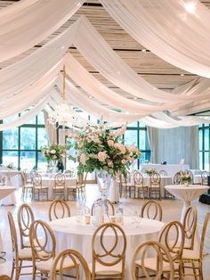 a banquet hall with tables and chairs covered in white draping