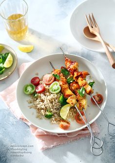 a white plate topped with chicken and veggies next to silver utensils