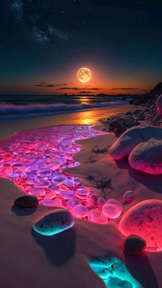 the beach is covered in glowing rocks and pebbles at night, while the moon shines brightly