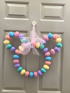 a door with a wreath made out of candy eggs and a bow on the front