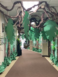 an office hallway decorated with paper trees and plants