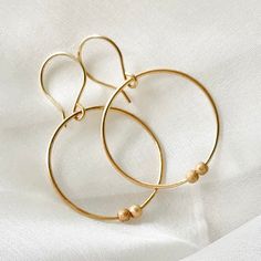 🌷These gorgeous gold filled beaded hoop earrings, have been handmade. The 2x 3 mm gold filled sparkle beads can move around the hoops. These stylish medium sized hoops will make a wonderful Christmas gift for a girlfriend, or birthday gift for your sister, or even a lovely self gift to add to your own jewelry collection. 🌷Earring size:30mm x 30mm 1.2mm gauge 14k gold filled Two 3 mm gold filled stardust beads 🌷Delivery: Your earrings will arrive gift wrapped and in a lovely gift pouch and wil Gold Tiny Beads Drop Earrings, Gold Drop Earrings With Tiny Beads, Delicate Gold Hoop Earrings For Everyday, Delicate 14k Gold Filled Hoop Earrings For Everyday, Dainty 14k Gold-filled Hoop Earrings For Everyday, Dainty Brass Hoop Earrings For Everyday, Gold Brass Earrings With Tiny Beads, Gold Earrings With Tiny Beads In Brass, Gold Dangle Hoop Earrings Minimalist Style