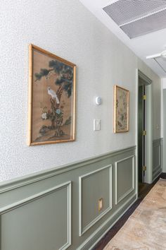 two paintings hang on the wall next to each other in a room with green paneling