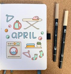 an open notebook with the words april written on it next to some markers and pencils