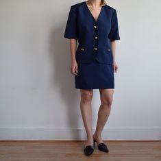 Vintage navy blue skirt suite. Great vintage condition. Made in Ireland by Paul Costelloe in 90's. Two side pocket blazer, fully lined. Golden buttons. Originally women's size big M depending on desire fit but please check measurements carefully. Classic.  Skirt  Waist 75cm=29'5 Across hip area laying flat 50cm=19'5 Total length 48cm=19' Blazer Armpit to armpit laying flat 52cm=20'5 Sleeve from armpit 13.5cm=5'5 Total length 64cm=25' Model is 164cm=5'4 tall UK size 10. Tailored Summer Skirt Suit For Workwear, Tailored Skirt Suit For Summer Workwear, Vintage Navy Blazer For Work, Navy Fitted Vintage Blazer, Vintage Navy Blazer For Workwear, Paul Costelloe, Cream Silk Blouse, Navy Blue Skirt, Womens Suits