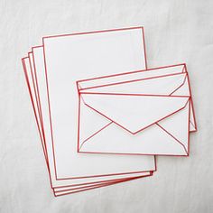 four envelopes lined up on top of each other with red paper sticking out of them