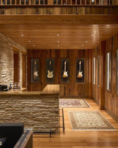 a living room filled with furniture and pictures on the wall next to a stone bar