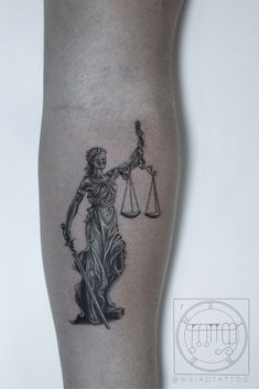 a lady justice tattoo on the leg