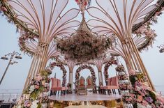 an elaborately decorated dining area with pink chairs and flowers on the ceiling, along with chandelier