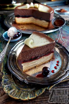 two pieces of cake on a plate with spoons and silverware next to it